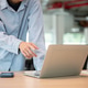 Close up of a man's hand pointing at laptop screen while standing leaning over wooden table in cafe. Close up of a man's hand pointing at laptop screen while standing leaning over wooden table in cafe. - PhotoDune Item for Sale