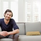 Smiling man sitting on sofa Smiling man sitting on sofa - PhotoDune Item for Sale