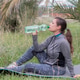A woman drinks clean water before a fitness class in a park. Active recreation and wellness A woman drinks clean water before a fitness class in a park. Active recreation and wellness - PhotoDune Item for Sale