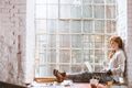 Woman sitting on windowsill with notebook Woman sitting on windowsill with notebook - PhotoDune Item for Sale