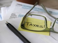 The word Taxes through the glasses of a person filing taxes with tax forms in background The word Taxes through the glasses of a person filing taxes with tax forms in background - PhotoDune Item for Sale