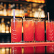Four Red Cocktails With Straws On Bar Four Red Cocktails With Straws On Bar - PhotoDune Item for Sale