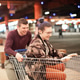 ✓ ↟ Cheerful happy young couple in casual clothes having fun and riding on a shopping cart ✓ ↟ Cheerful happy young couple in casual clothes having fun and riding on a shopping cart - PhotoDune Item for Sale
