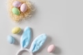 Easter bunny ears, nest and pastel colorful eggs on gray background. Easter bunny ears, nest and pastel colorful eggs on gray background. - PhotoDune Item for Sale