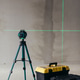 Laser Level On Tripod Projecting Green Cross Lines Beside Tool Cases Laser Level On Tripod Projecting Green Cross Lines Beside Tool Cases - PhotoDune Item for Sale