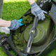 Cleaning the Lawn Mower of Mowing Grass and Trimming Edges. Hands in gloves. Upside down mower Cleaning the Lawn Mower of Mowing Grass and Trimming Edges. Hands in gloves. Upside down mower - PhotoDune Item for Sale