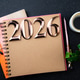New year goals 2026 on desk. 2026 resolutions list with notebook, plant on black table New year goals 2026 on desk. 2026 resolutions list with notebook, plant on black table - PhotoDune Item for Sale