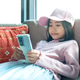 Young Asian girl sitting on a sofa using a smartphone. Young Asian girl sitting on a sofa using a smartphone. - PhotoDune Item for Sale