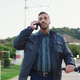 Man wearing leather jacket talking over smartphone while walking down the street with e-scooter Man wearing leather jacket talking over smartphone while walking down the street with e-scooter - PhotoDune Item for Sale