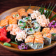 Sushi and rolls with sauce and spices on wooden plate with green leaves Sushi and rolls with sauce and spices on wooden plate with green leaves - PhotoDune Item for Sale