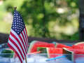 United States flags with watermelon pieces in the background during Independence Day celebration. United States flags with watermelon pieces in the background during Independence Day celebration. - PhotoDune Item for Sale