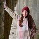 Young woman in red beanie and pink scarf leaning on stone wall in cold outdoor corridor Young woman in red beanie and pink scarf leaning on stone wall in cold outdoor corridor - PhotoDune Item for Sale