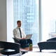 Busy professional business man working on laptop in modern office lobby. Busy professional business man working on laptop in modern office lobby. - PhotoDune Item for Sale