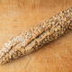 Rustic multigrain baguette with oat seeds on wooden cutting board. Rustic multigrain baguette with oat seeds on wooden cutting board. - PhotoDune Item for Sale