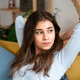 Young woman stretching her arms sitting on the sofa at home. Young woman stretching her arms sitting on the sofa at home. - PhotoDune Item for Sale