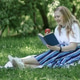 A blonde woman with a laptop works in the garden, a green home office concept. A blonde woman with a laptop works in the garden, a green home office concept. - PhotoDune Item for Sale