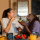 Lesbian couple sharing a laugh and healthy breakfast at home Lesbian couple sharing a laugh and healthy breakfast at home - PhotoDune Item for Sale