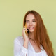 Beautiful red hair woman in casual shirt on green background talk on mobile phone smile and laugh Beautiful red hair woman in casual shirt on green background talk on mobile phone smile and laugh - PhotoDune Item for Sale