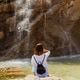 Woman sitting on a rock near a waterfall Woman sitting on a rock near a waterfall - PhotoDune Item for Sale