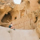 Young woman tourist exploring a carved cave in a cliff Young woman tourist exploring a carved cave in a cliff - PhotoDune Item for Sale