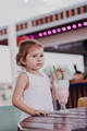 Toddler girl wear white mockup t-shirt drinking milk shake at outdoor cafe, vertical image Toddler girl wear white mockup t-shirt drinking milk shake at outdoor cafe, vertical image - PhotoDune Item for Sale