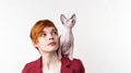 Beautiful hipster redhead young woman looking up and playful Sphynx kitten sitting on her shoulder Beautiful hipster redhead young woman looking up and playful Sphynx kitten sitting on her shoulder - PhotoDune Item for Sale