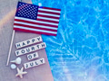 Flat lay with Happy Fourth of July written with tiles with USA flag sea shells & pool background Flat lay with Happy Fourth of July written with tiles with USA flag sea shells & pool background - PhotoDune Item for Sale