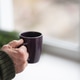 hands of an old man holding a cup of coffee on the background of a natural Christmas tree hands of an old man holding a cup of coffee on the background of a natural Christmas tree - PhotoDune Item for Sale