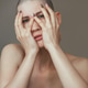 Young slender woman after chemotherapy without hair on her head covers her face with her hands Young slender woman after chemotherapy without hair on her head covers her face with her hands - PhotoDune Item for Sale