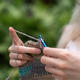 Close-up of woman hands crocheting against a nature background Close-up of woman hands crocheting against a nature background - PhotoDune Item for Sale