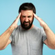 Man suffering from strong headache, pressing hands to head on blue background Man suffering from strong headache, pressing hands to head on blue background - PhotoDune Item for Sale