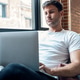 Smart man working with her laptop while sitting on a couch at home Smart man working with her laptop while sitting on a couch at home - PhotoDune Item for Sale