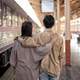 Back view image of a lovely Asian couple wrapping around shoulder while walking down the platform. Back view image of a lovely Asian couple wrapping around shoulder while walking down the platform. - PhotoDune Item for Sale