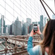 Woman capturing Manhattan skyline from Brooklyn Bridge Woman capturing Manhattan skyline from Brooklyn Bridge - PhotoDune Item for Sale