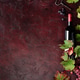 Red Wine Bottle with Grapes and Vine Leaves on Rustic Background Red Wine Bottle with Grapes and Vine Leaves on Rustic Background - PhotoDune Item for Sale