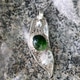 Elegant Silver Pendant with Green Gemstone on Granite Surface. Nature Inspired Jewelry. Elegant Silver Pendant with Green Gemstone on Granite Surface. Nature Inspired Jewelry. - PhotoDune Item for Sale