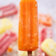 Orange popsicle on ice pops and colorful popsicles Orange popsicle on ice pops and colorful popsicles - PhotoDune Item for Sale