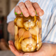 Hands holding jar of pickled garlic. National Pickle Day Hands holding jar of pickled garlic. National Pickle Day - PhotoDune Item for Sale