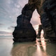 The sunrise behind the arches of As Catedrais beach The sunrise behind the arches of As Catedrais beach - PhotoDune Item for Sale