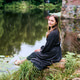 Young woman with long brown hair sitting peacefully by lake near stone building Young woman with long brown hair sitting peacefully by lake near stone building - PhotoDune Item for Sale
