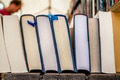 Second hand hardback reading books, literature in a row on a market stall. Blurred background. Second hand hardback reading books, literature in a row on a market stall. Blurred background. - PhotoDune Item for Sale