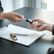 salesman holding rental contract and hand over car key to client while he is holding pen to signing salesman holding rental contract and hand over car key to client while he is holding pen to signing - PhotoDune Item for Sale