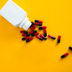Medicine bottle spilling red and black capsules Medicine bottle spilling red and black capsules - PhotoDune Item for Sale