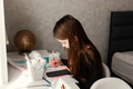 Preteen girl sitting at table, using smartphone, holding colorful pencil, drawing Preteen girl sitting at table, using smartphone, holding colorful pencil, drawing - PhotoDune Item for Sale