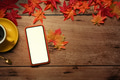 Mock up smart phone, coffee cup and autumn maple leaves on wooden table. Mock up smart phone, coffee cup and autumn maple leaves on wooden table. - PhotoDune Item for Sale