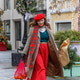 A woman in a red clothes with a bouquet of fir branches walks along the Christmas decorated streets A woman in a red clothes with a bouquet of fir branches walks along the Christmas decorated streets - PhotoDune Item for Sale