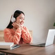 A woman wearing headphones is smiling while looking at a laptop A woman wearing headphones is smiling while looking at a laptop - PhotoDune Item for Sale