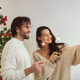 Couple Celebration New Year Near Christmas Tree at Home, Video Call or Selfie on Smartphone Couple Celebration New Year Near Christmas Tree at Home, Video Call or Selfie on Smartphone - PhotoDune Item for Sale