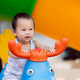 A happy young toddler playing on a colorful spring rider at an outdoor playground. A happy young toddler playing on a colorful spring rider at an outdoor playground. - PhotoDune Item for Sale
