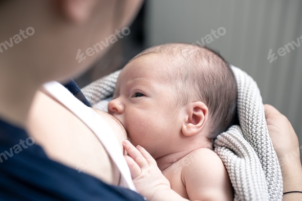 Portrait of a newborn baby boy drinking mother's breast milk
